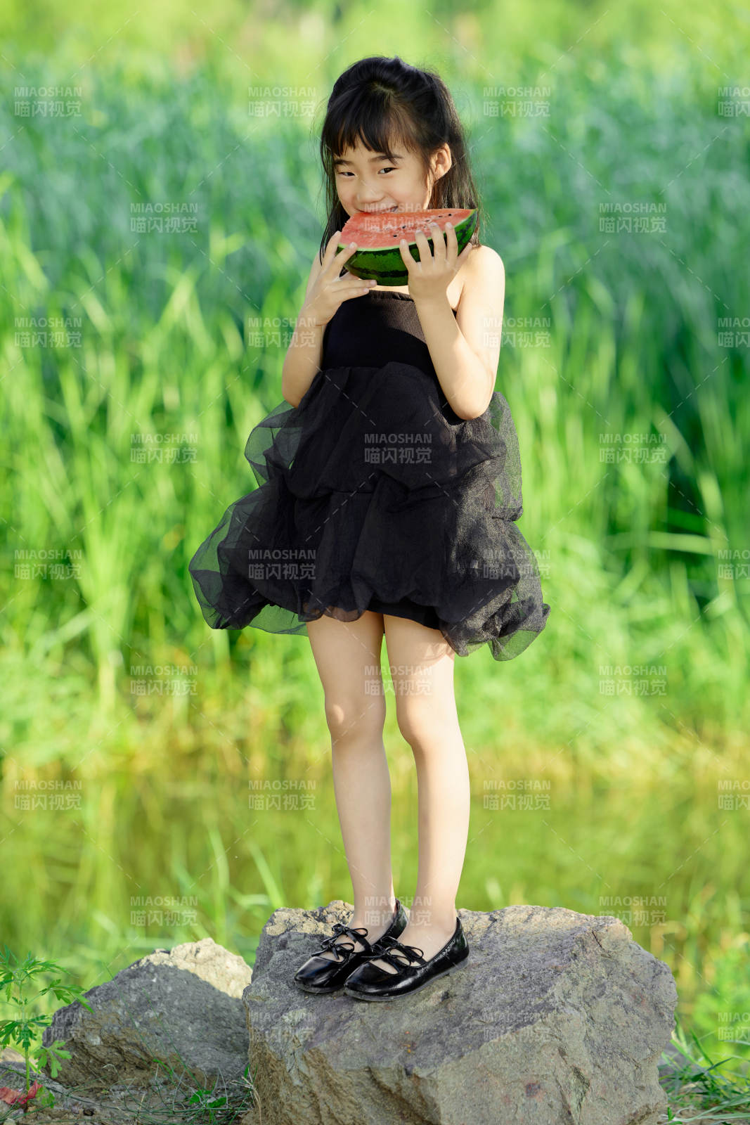夏季在户外游玩吃西瓜的可爱亚洲女童图片