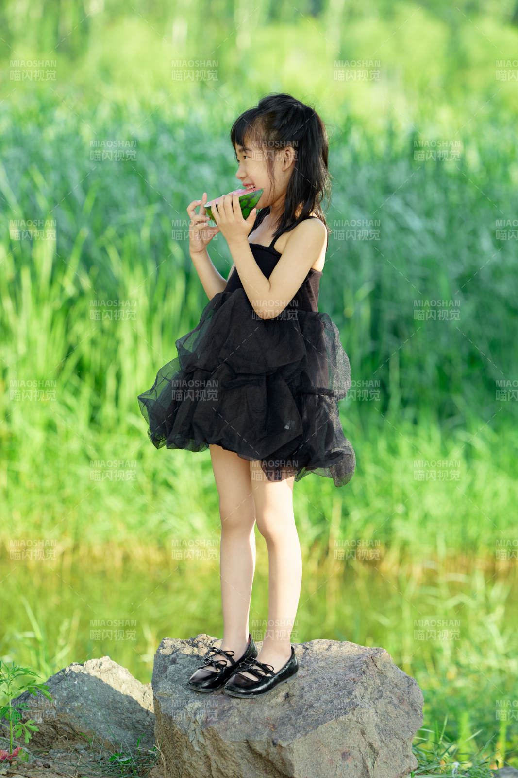 夏季在户外游玩吃西瓜的可爱亚洲女童图片