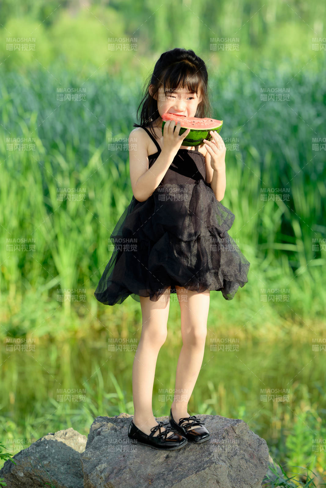 夏季在户外游玩吃西瓜的可爱亚洲女童图片