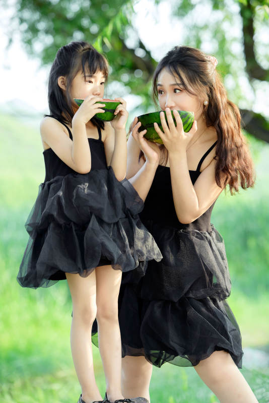 夏天在户外公园吃西瓜的亚洲母女亲子图片