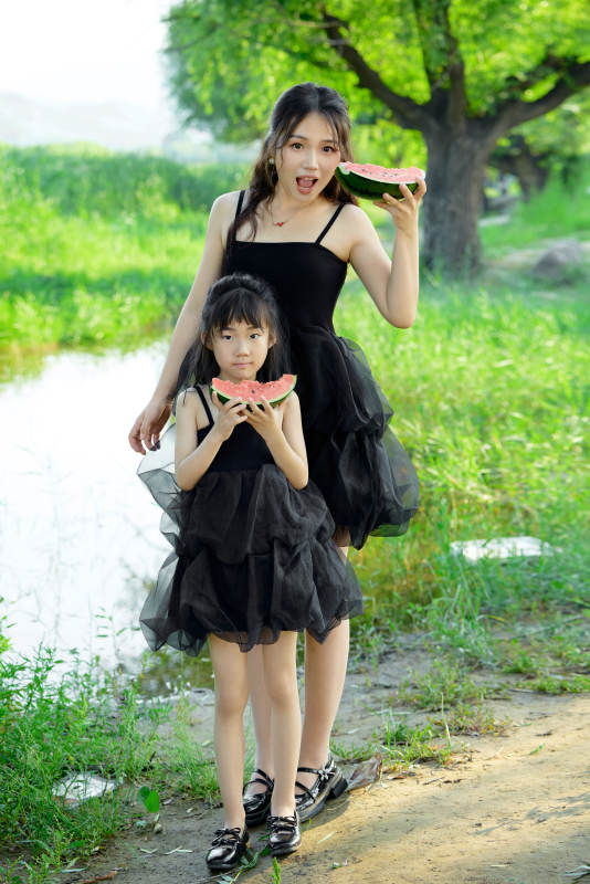 夏天在户外公园吃西瓜的亚洲母女亲子图片