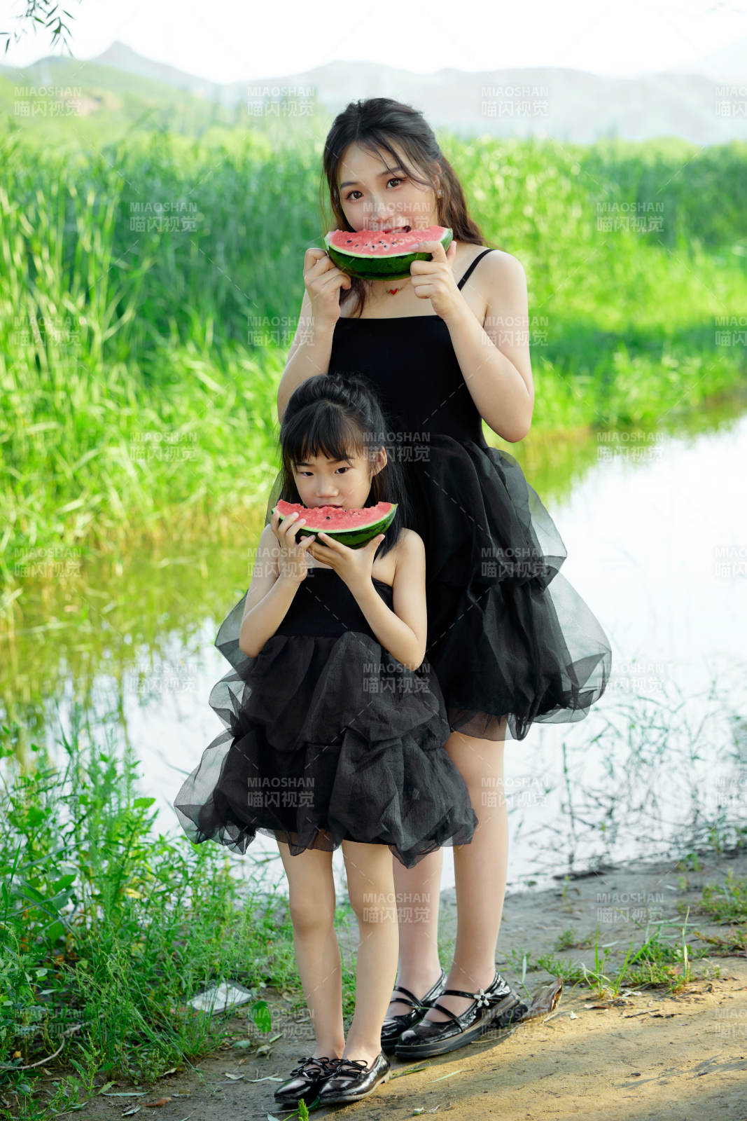 夏天在户外公园吃西瓜的亚洲母女亲子图片