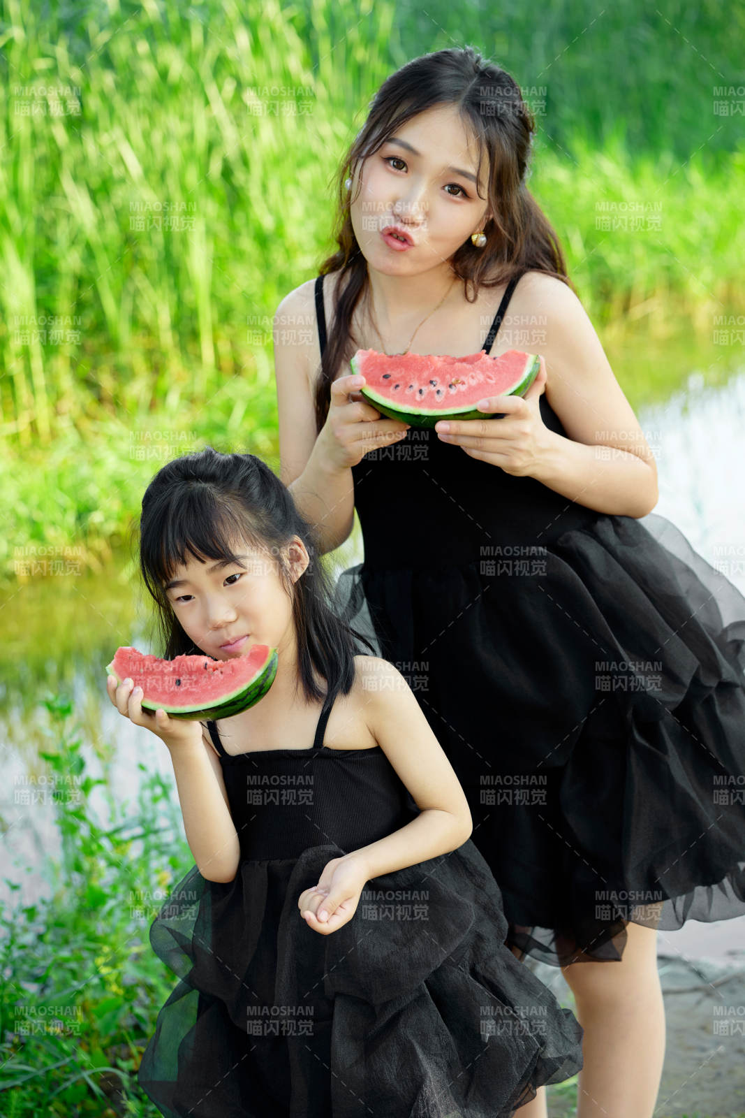 夏天在户外公园吃西瓜的亚洲母女亲子图片