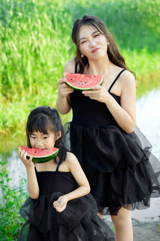 夏天在户外公园吃西瓜的亚洲母女亲子图片