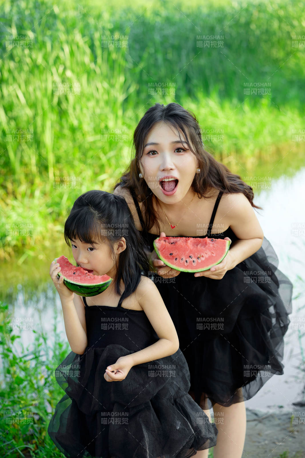 夏天在户外公园吃西瓜的亚洲母女亲子图片