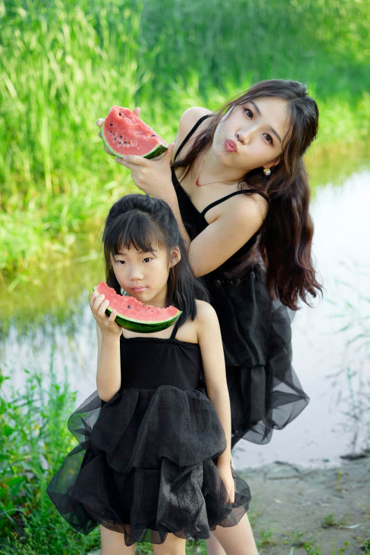 夏天在户外公园吃西瓜的亚洲母女亲子图片