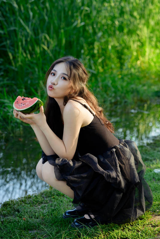 夏天在户外公园吃西瓜的亚州美女图片