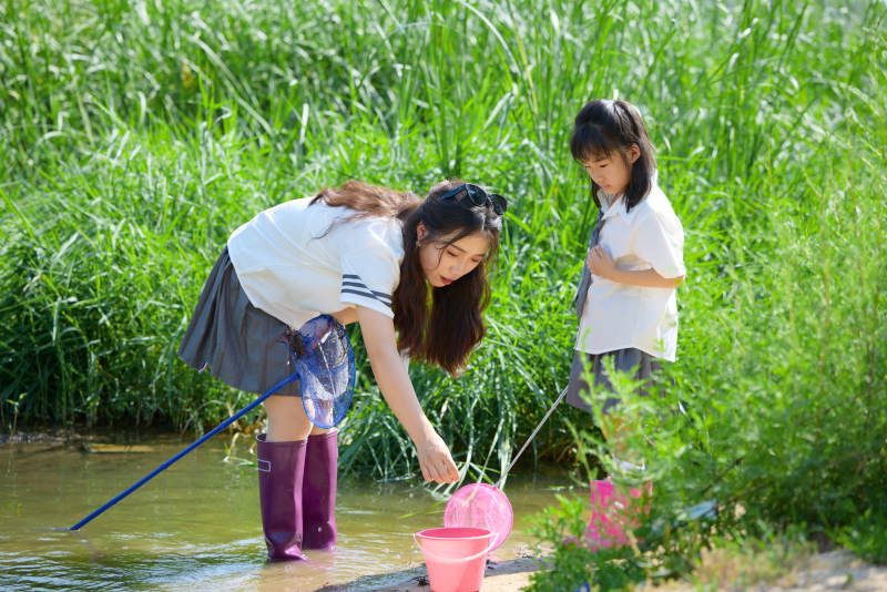 夏天在户外溪流捕捉鱼虾的母女亲子图片