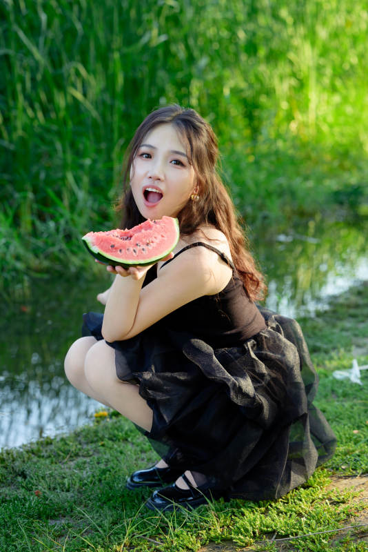 夏天在户外公园吃西瓜的亚州美女图片