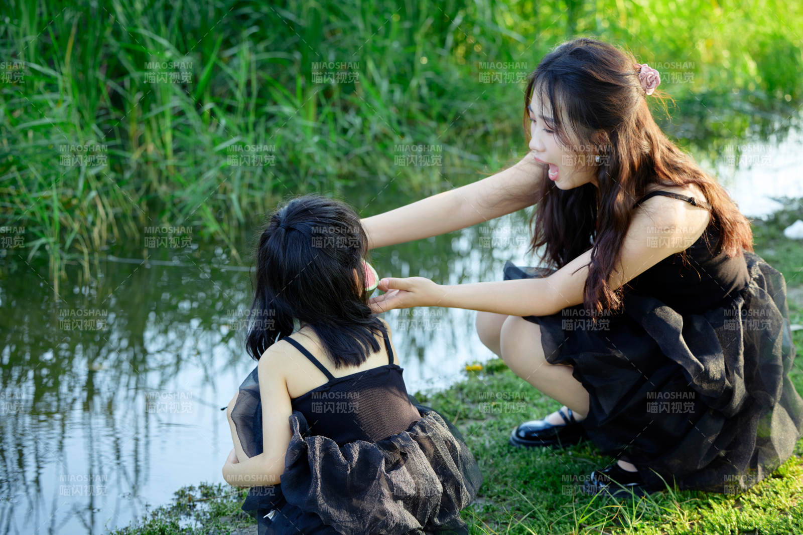 夏天在户外公园吃西瓜的亚洲母女亲子图片