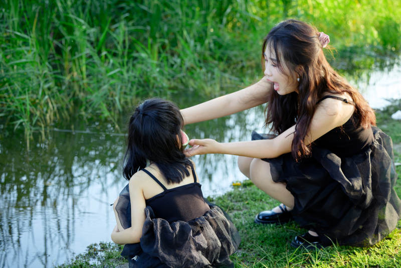 夏天在户外公园吃西瓜的亚洲母女亲子图片