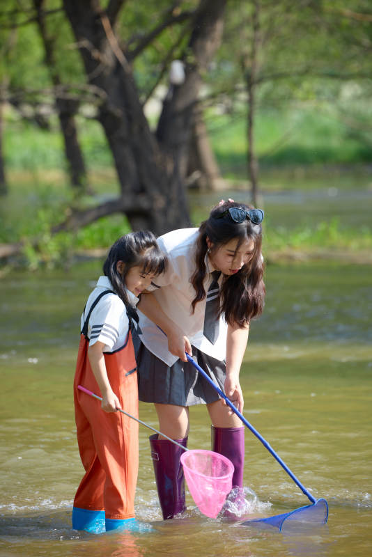 夏天在户外溪流捕捉鱼虾的母女亲子图片