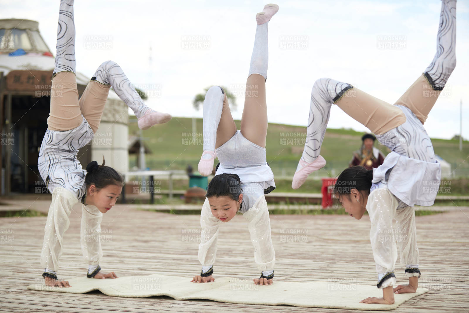 进行柔术体操杂技表演的三个少女图片