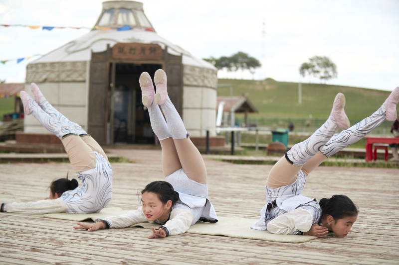 进行柔术体操杂技表演的三个少女图片