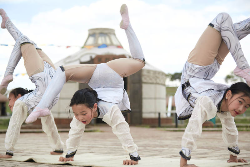 进行柔术体操杂技表演的三个少女图片