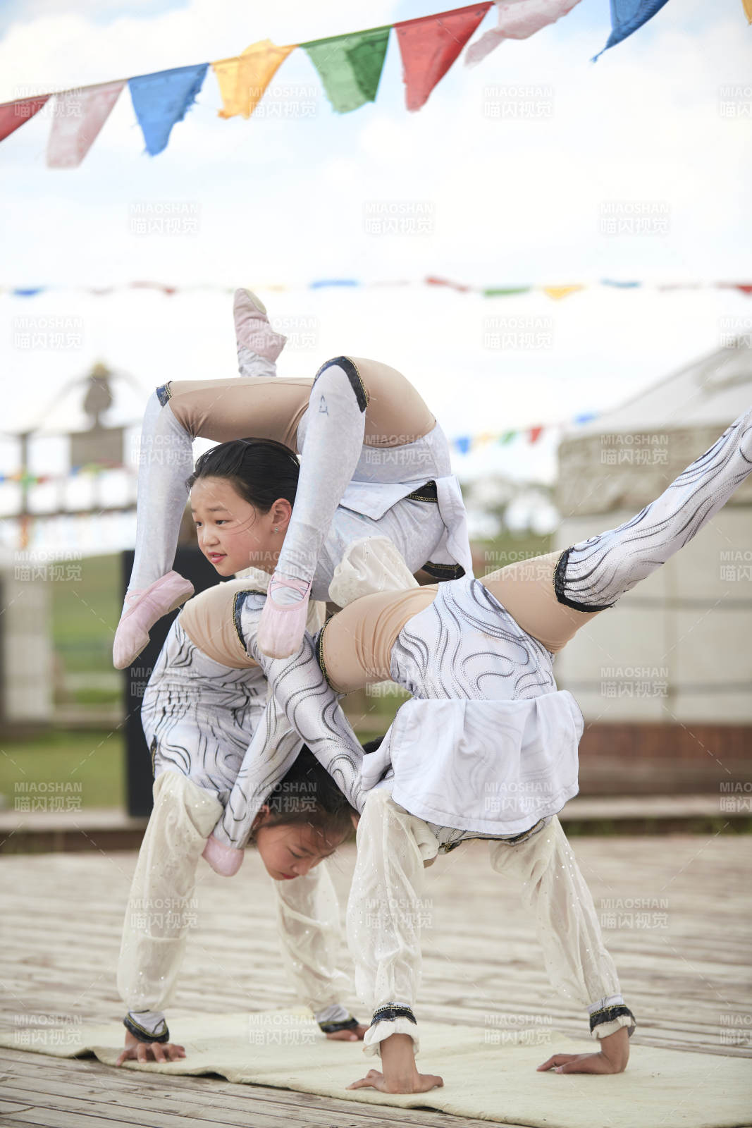 进行柔术体操杂技表演的三个少女图片