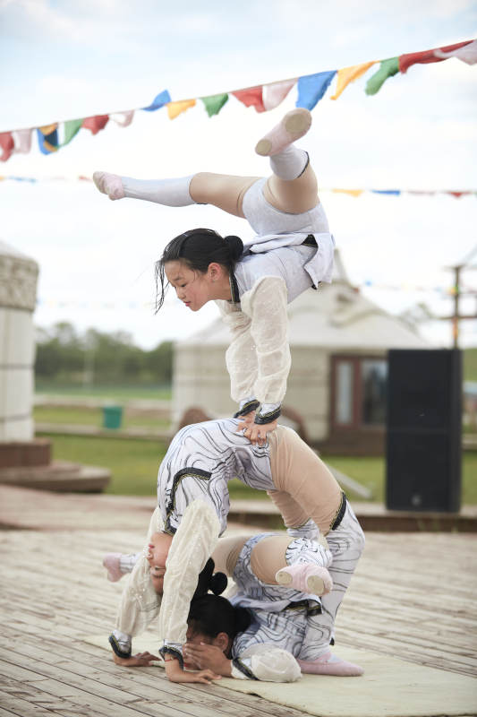 进行柔术体操杂技表演的三个少女图片