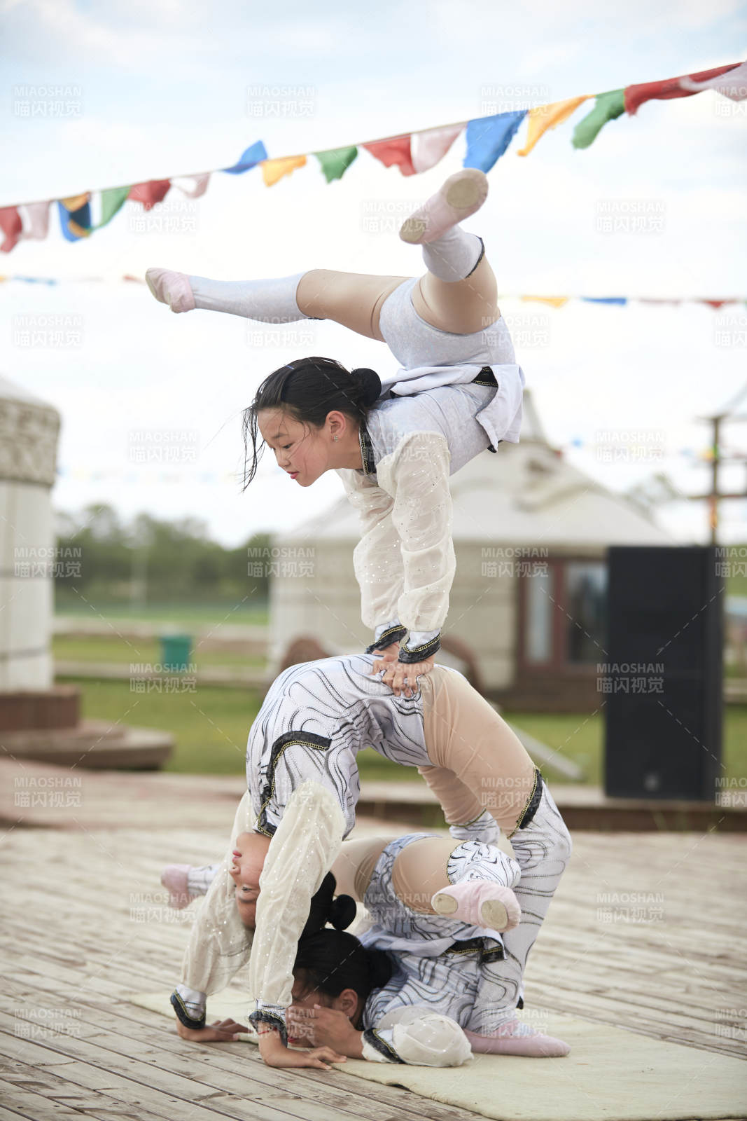 进行柔术体操杂技表演的三个少女图片