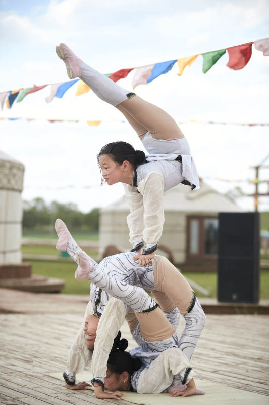 进行柔术体操杂技表演的三个少女图片