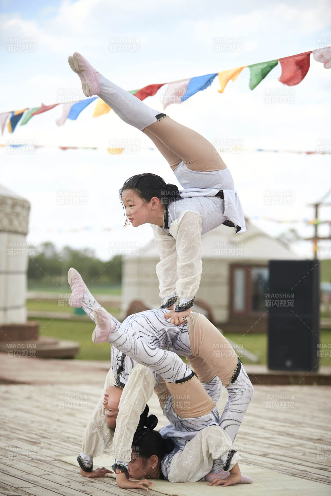 进行柔术体操杂技表演的三个少女图片