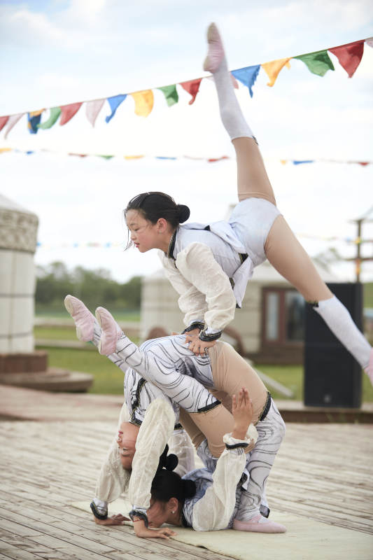 进行柔术体操杂技表演的三个少女图片