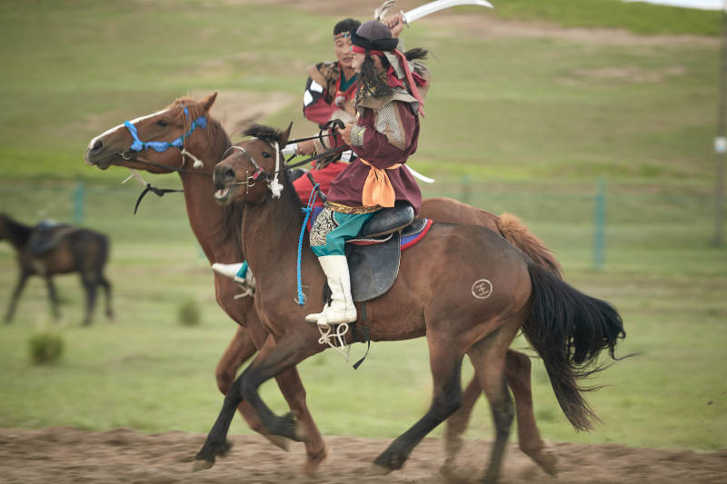 在草原景区表演的蒙古古代骑马打仗演出图片