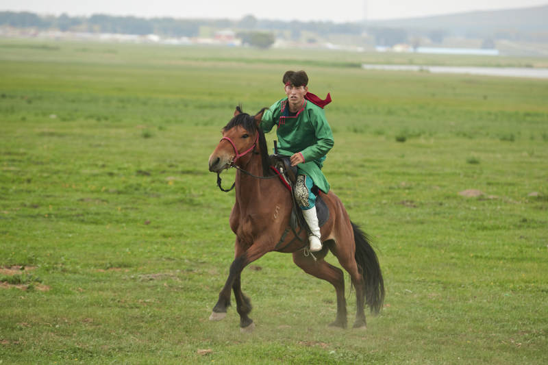 草原那达慕大会上骑着马的蒙古演员图片