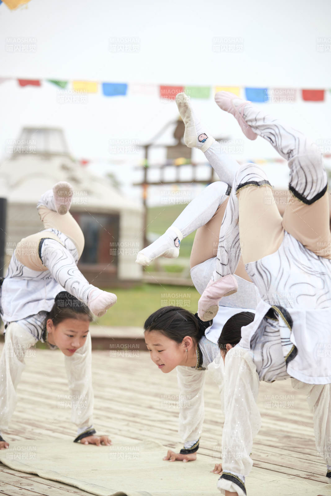 进行柔术体操杂技表演的三个少女图片