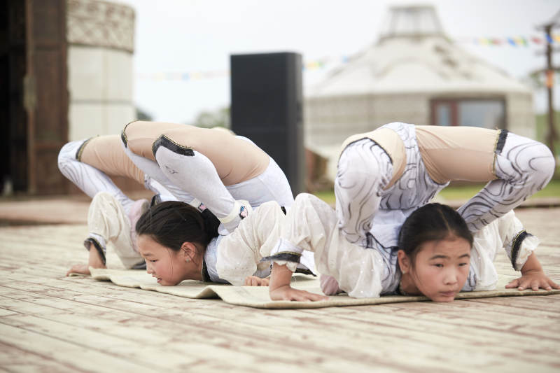 进行柔术体操杂技表演的三个少女图片