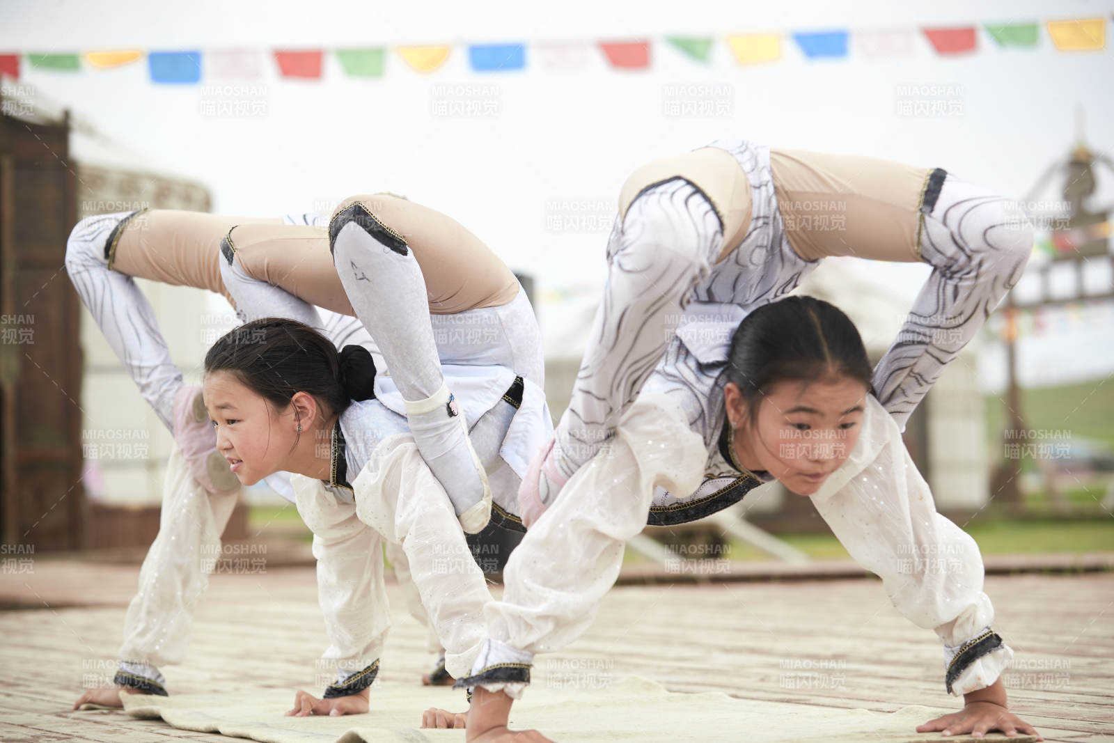 进行柔术体操杂技表演的三个少女图片
