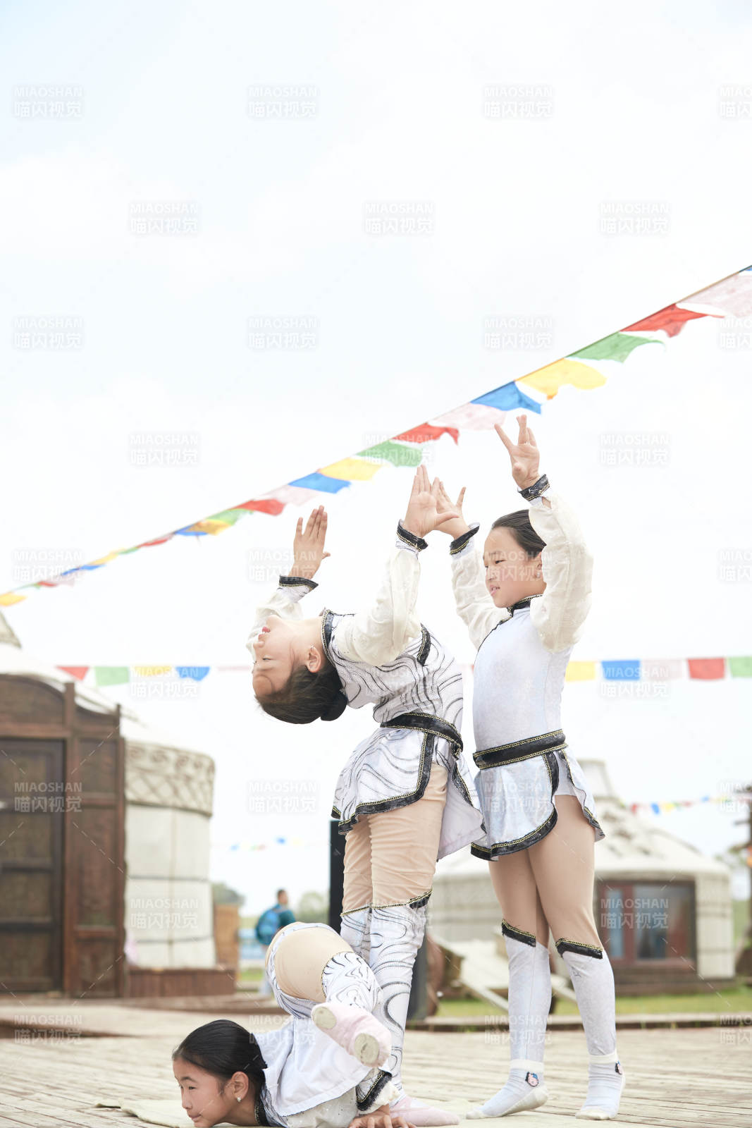 进行柔术体操杂技表演的三个少女图片