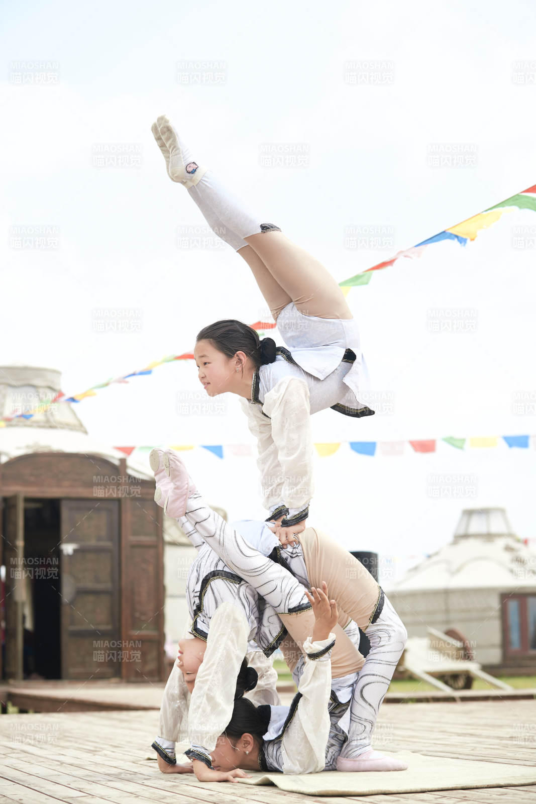 进行柔术体操杂技表演的三个少女图片