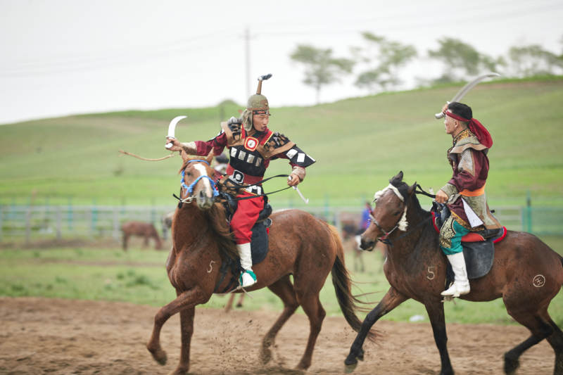 在草原景区表演的蒙古古代骑马打仗演出图片