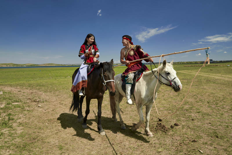 草原那达慕大会上骑着马的蒙古演员图片