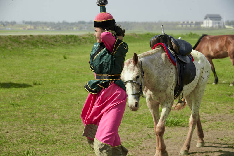 草原那达慕大会上骑着马的蒙古演员图片
