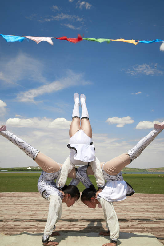 进行柔术体操杂技表演的三个少女图片