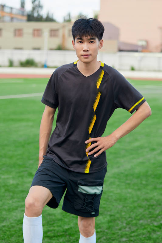 户外足球场上踢足球的运动员图片