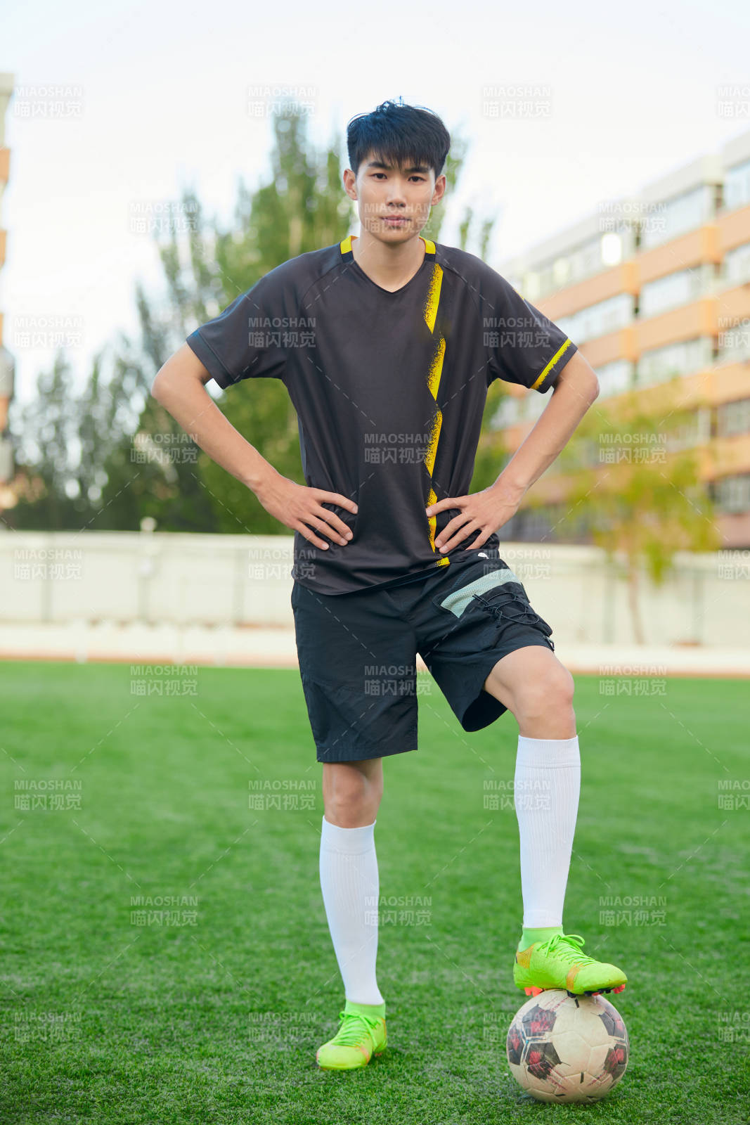 户外足球场上踢足球的运动员图片