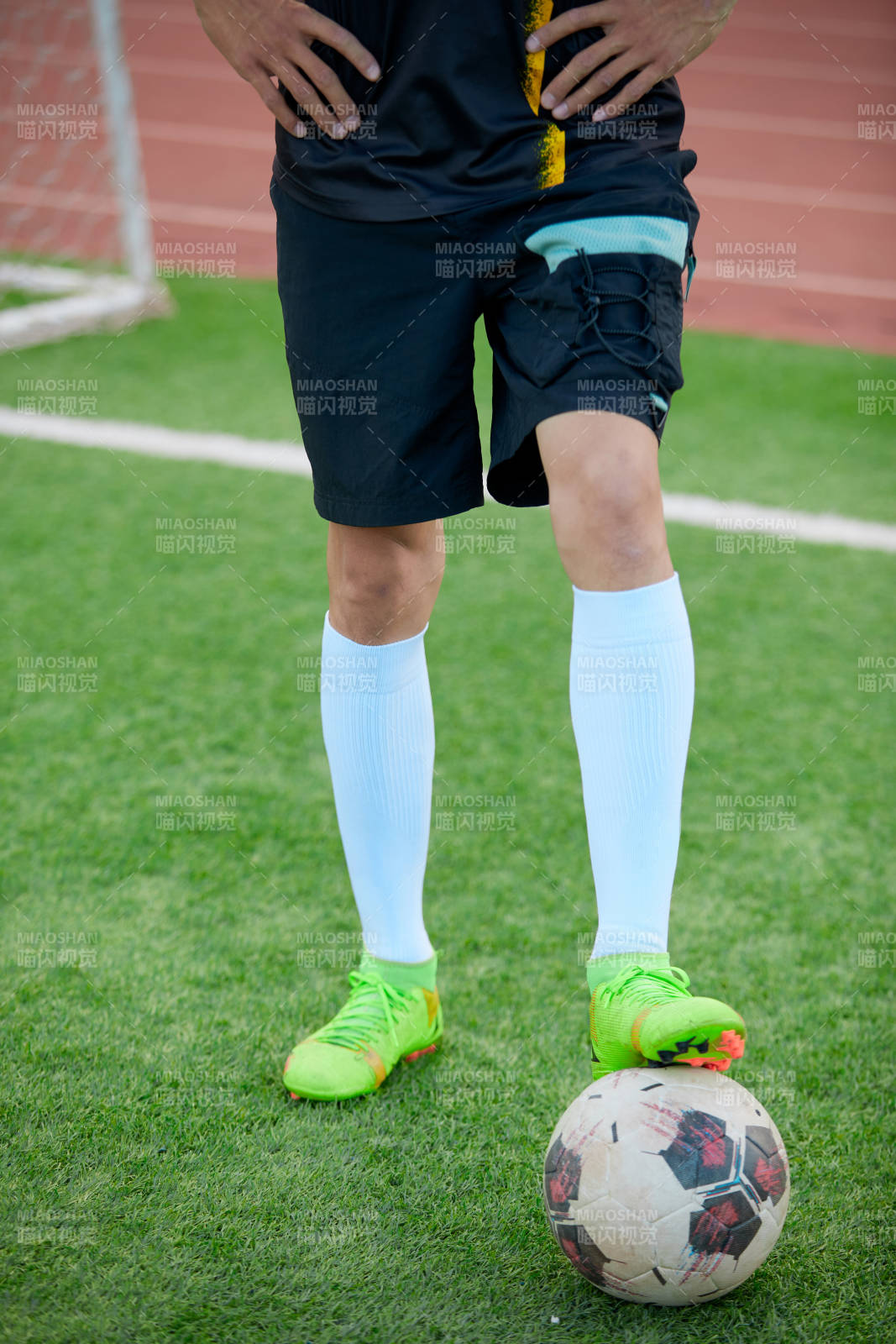 户外足球场上踢足球的运动员图片