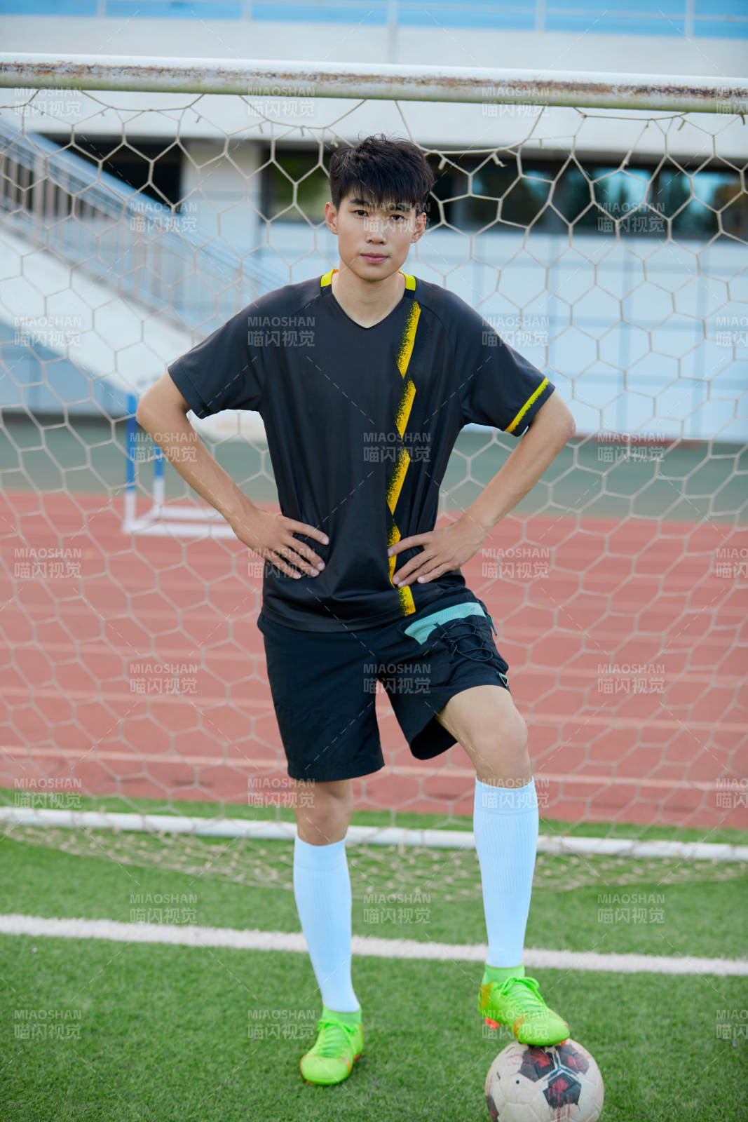 户外足球场上踢足球的运动员图片