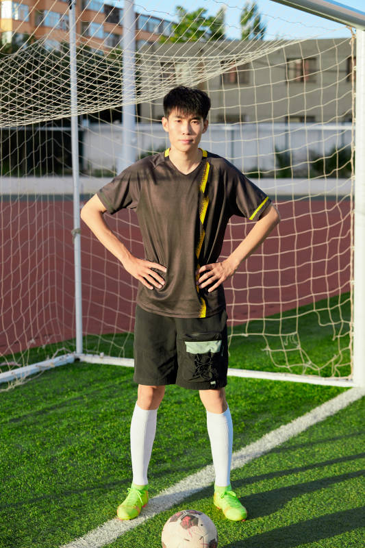 户外足球场上踢足球的运动员图片