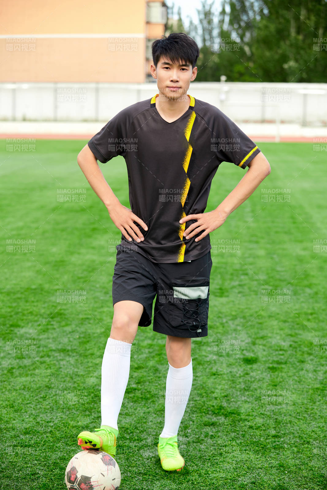 户外足球场上踢足球的运动员图片