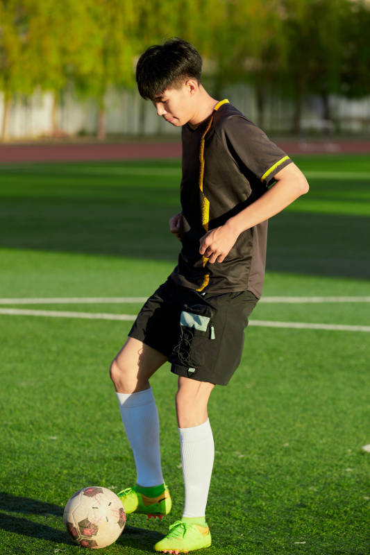 户外足球场上踢足球的运动员图片