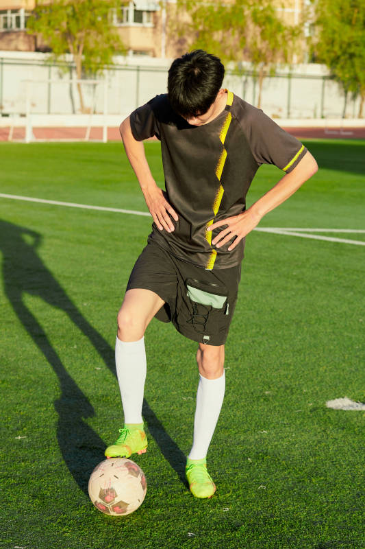 户外足球场上踢足球的运动员图片