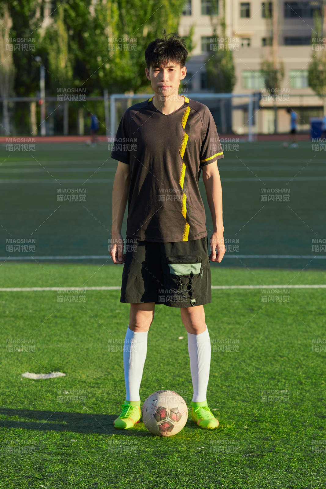 户外足球场上踢足球的运动员图片