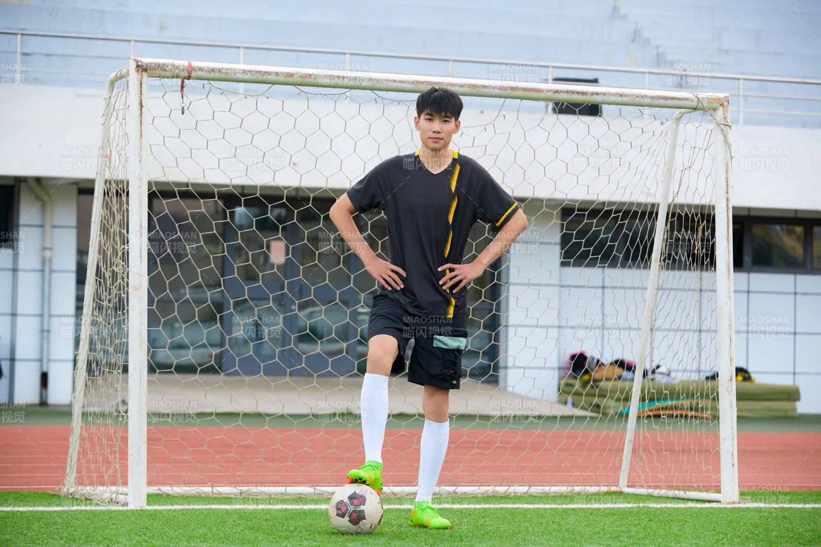 户外足球场上踢足球的运动员图片