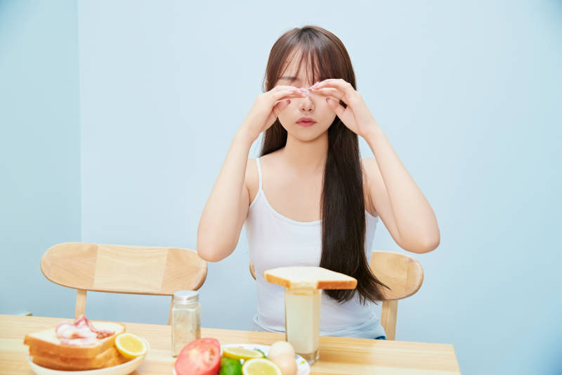 美丽的少女在餐桌前吃早餐图片