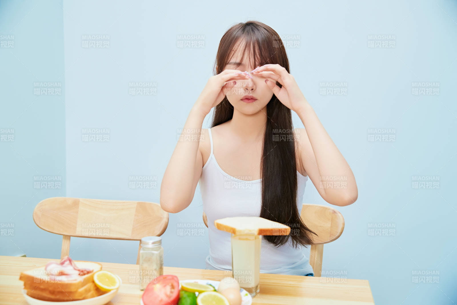 美丽的少女在餐桌前吃早餐图片