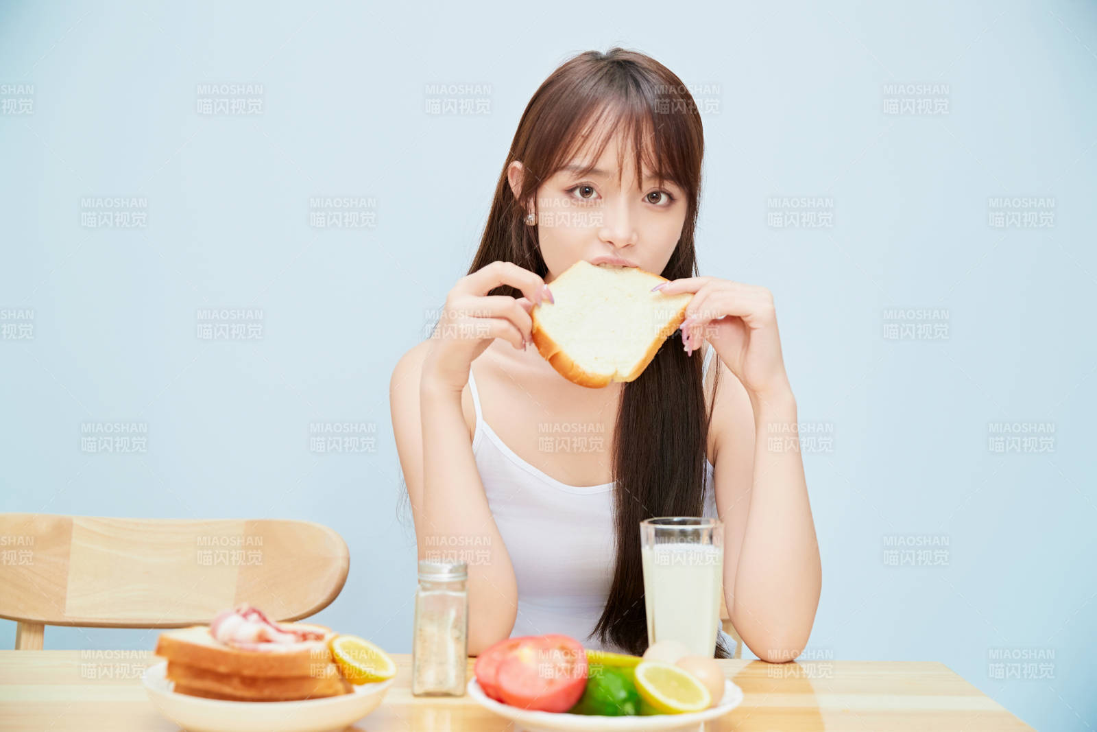 美丽的少女在餐桌前吃早餐图片