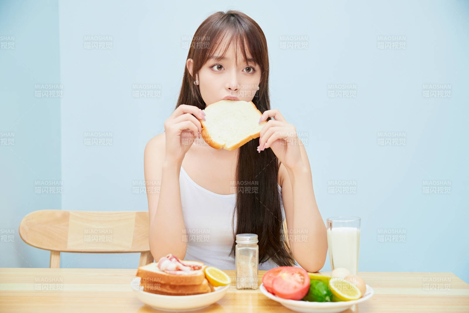 美丽的少女在餐桌前吃早餐图片